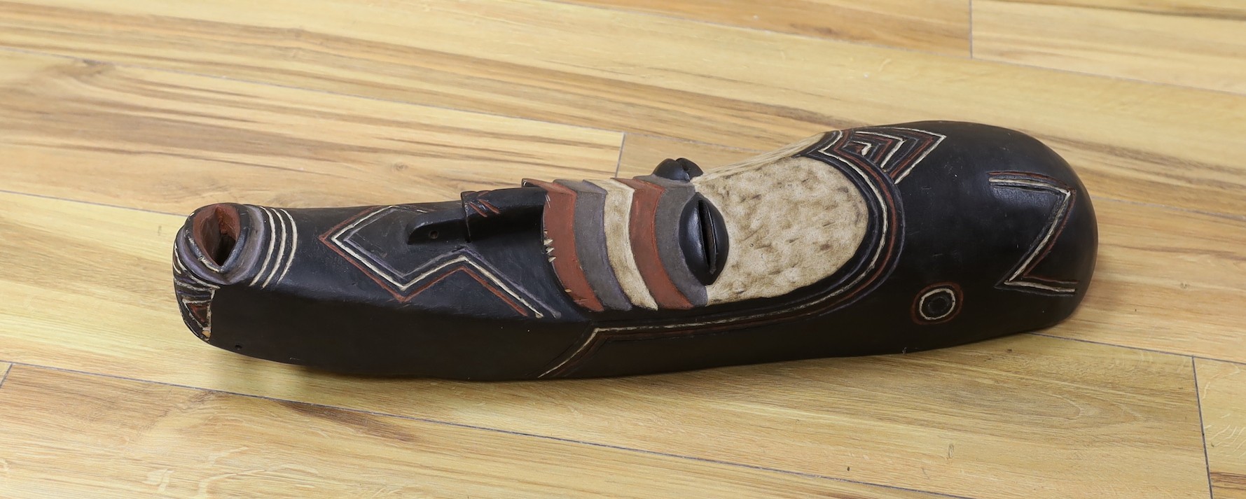 An African carved and painted wood mask. 64cm long